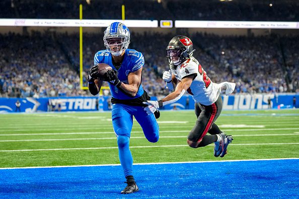 Amon-Ra St. Brown #14 of the Detroit Lions catches a pass for a touchdown in front of Zyon McCollum #27 of the Tampa Bay Buccaneers during the fourth quarter of the NFC Divisional Playoff game at Ford Field on January 21, 2024 in Detroit, Michigan.