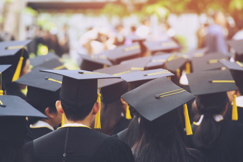 Students at high school graduation. Wearing cap and gown. Celebrating educational achievement