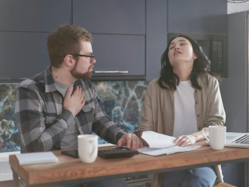 Photo of couple sitting at table discussing bills.