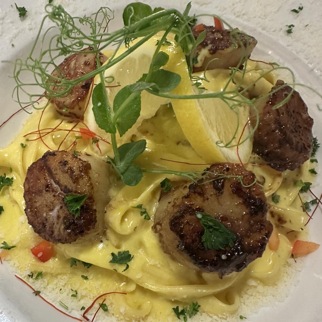A fancy plate of scallops with lemon and herbs at Amore Trattoria Italiana, the best restaurant in Grand Rapids